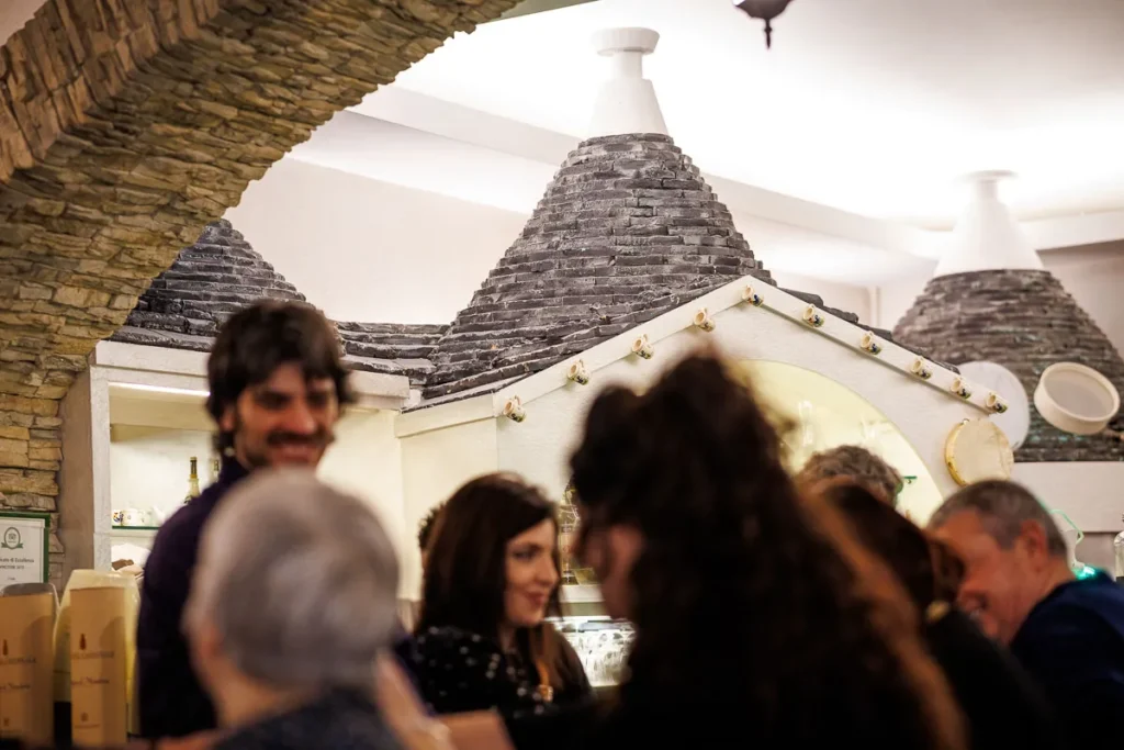 volti sorridenti davanti ai trulli tipici all'interno della trattoria il trullo a torino dove la tradizione pugliese incontra l'accoglienza familiare